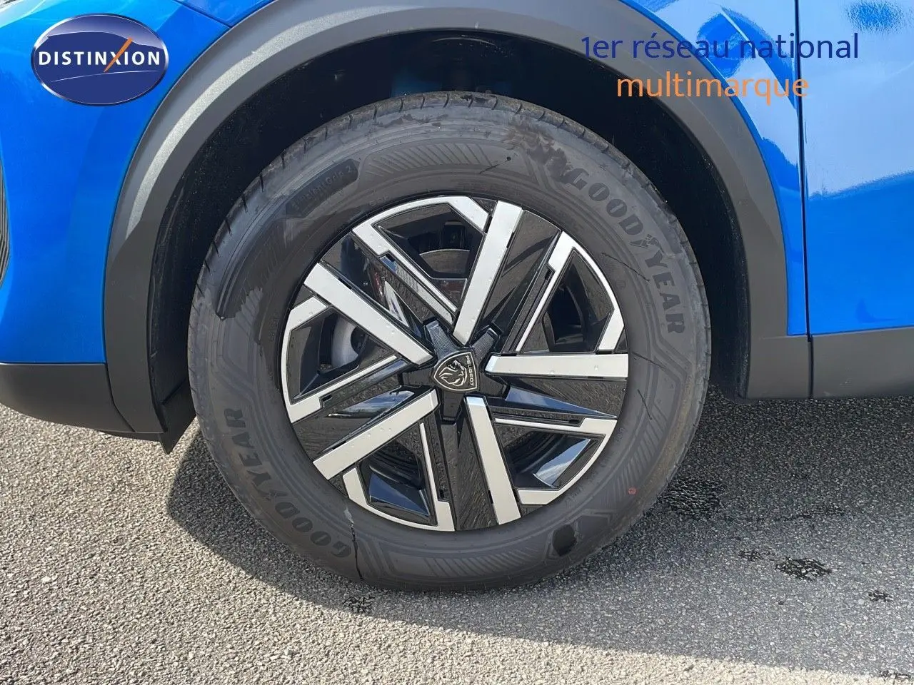 Gros plan sur la roue avant droite d’un Peugeot 2008 bleu Vertigo Metal avec jante noire et argentée.