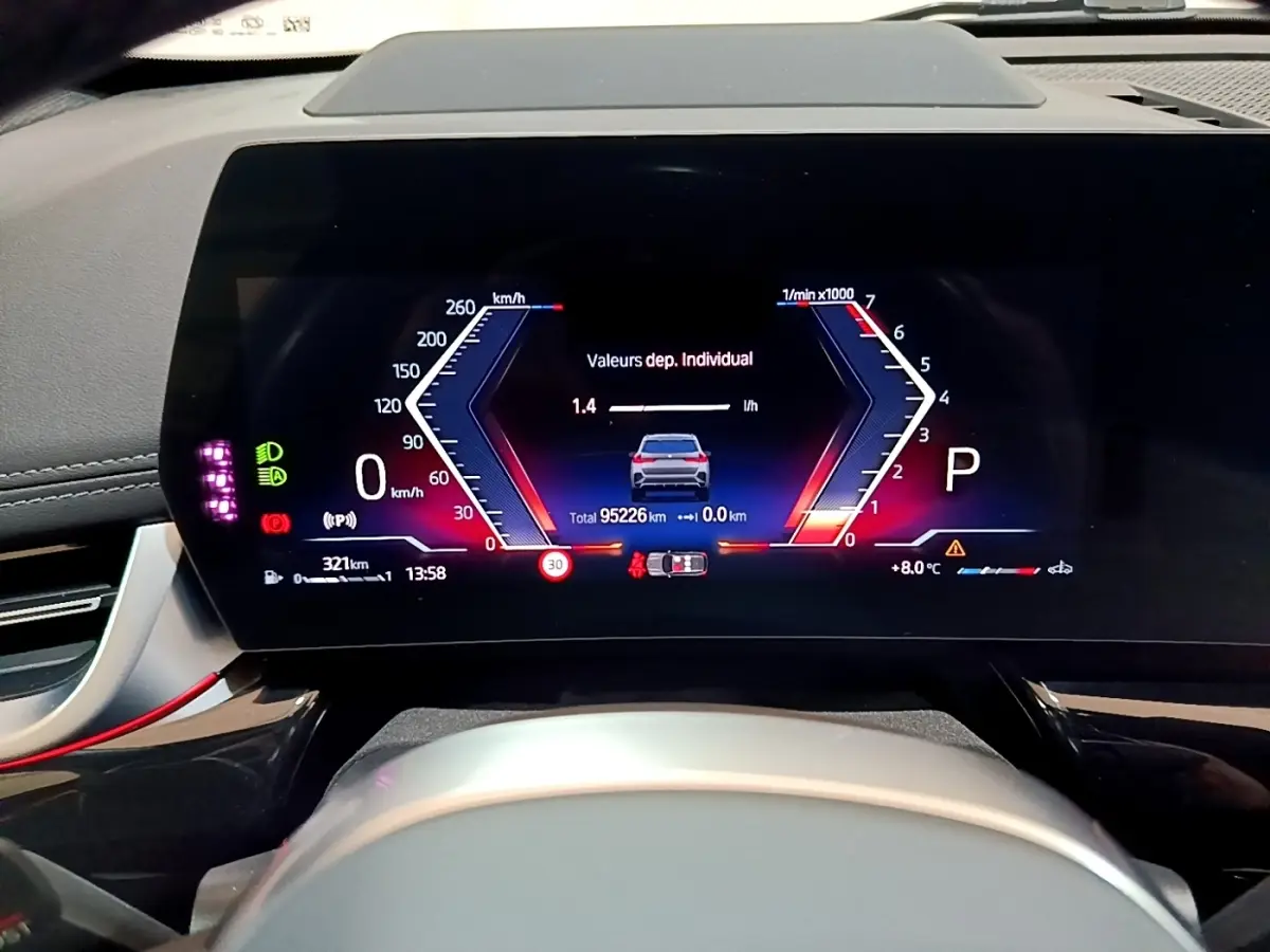 Vue rapprochée du tableau de bord numérique du BMW X1 xDrive23i M Sport gris clair, affichage multifonctions moderne.