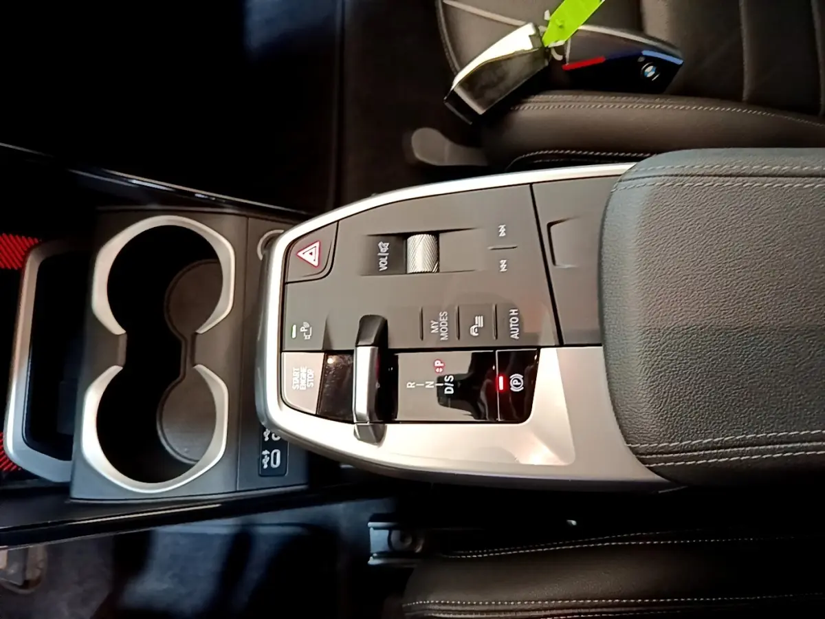 Gros plan sur la console centrale grise et noire du BMW X1 xDrive23i M Sport 2023 avec levier de vitesses et commandes tactiles.