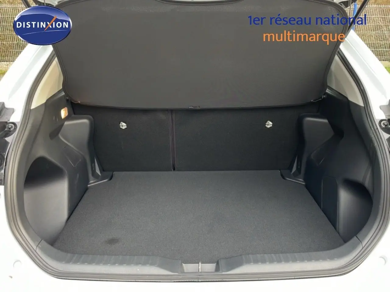 Vue ouverte du coffre spacieux et propre de la Toyota Yaris Cross blanc pur, version hybride 2024.