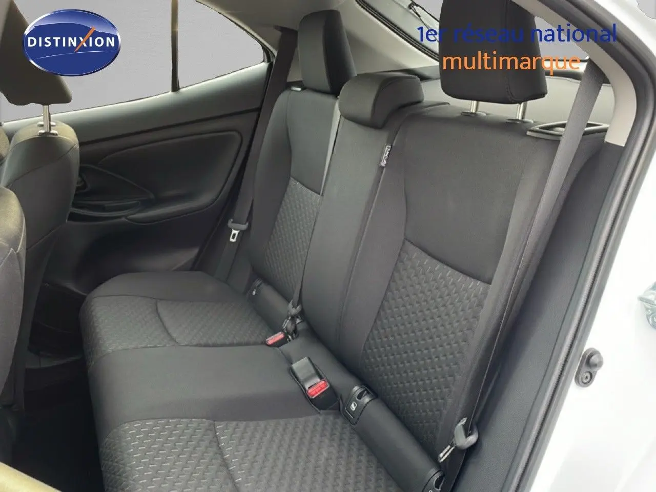 Vue intérieure côté droit montrant la banquette arrière en tissu noir de la Toyota Yaris Cross blanc pur 2024.