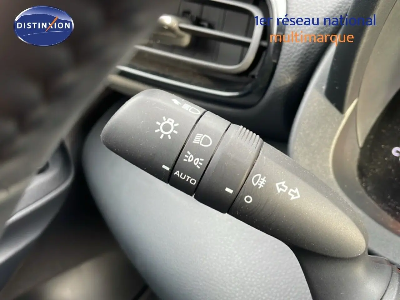 Gros plan sur la commande des phares et clignotants dans l’habitacle d’une Toyota Yaris Cross blanc pur 2024.