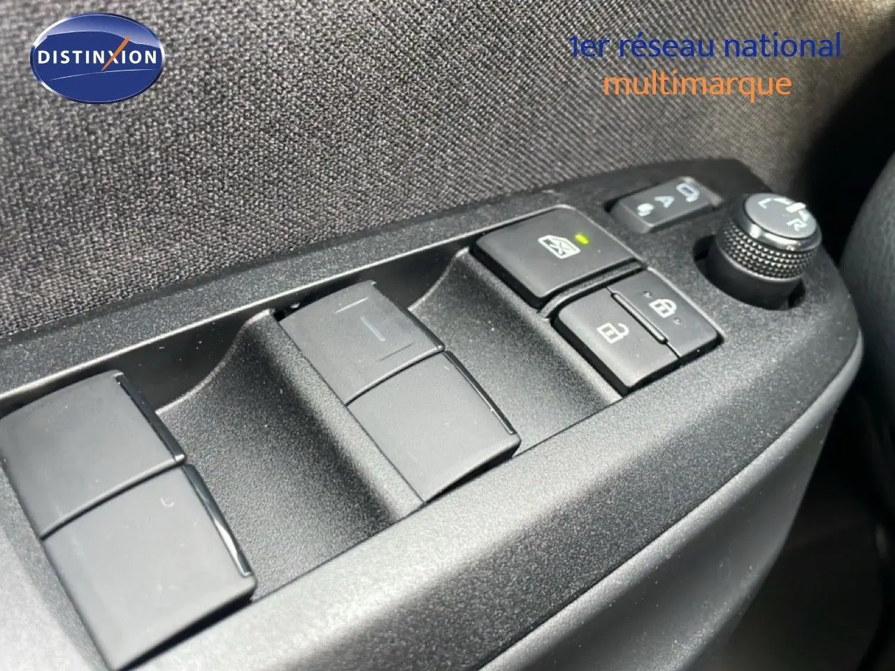 Gros plan sur les commandes de lève-vitres et réglage des rétroviseurs côté conducteur d'une Toyota Yaris Cross blanc pur 2024.