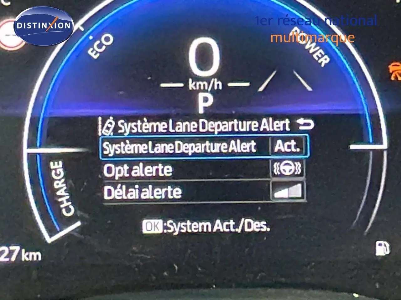 Tableau de bord numérique de Toyota Yaris Cross blanc, affichant l'alerte de sortie de voie activée en vue rapprochée.