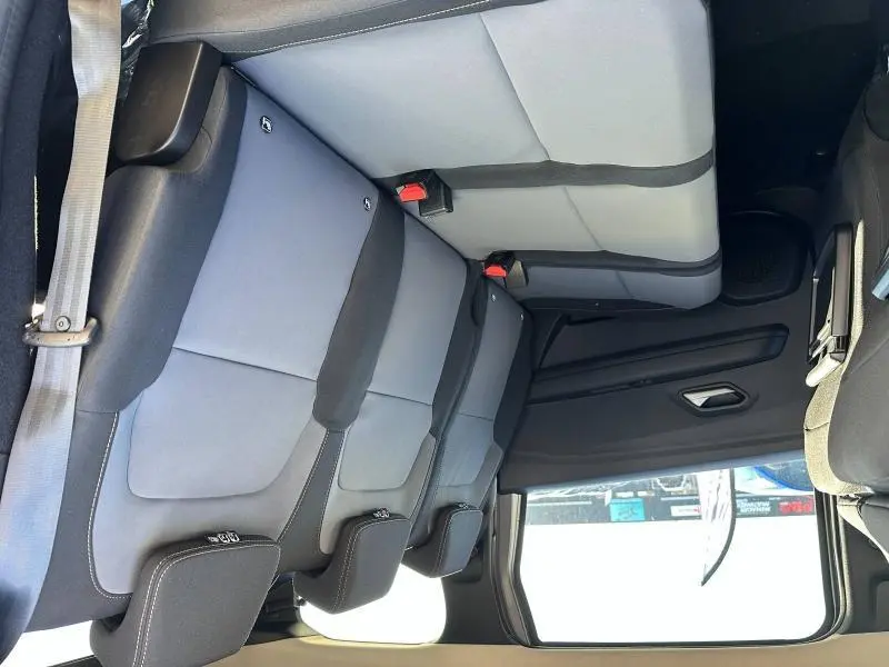 Vue latérale intérieure de la banquette arrière grise et noire du Dacia Jogger 2024 avec appuie-têtes et ceintures visibles.