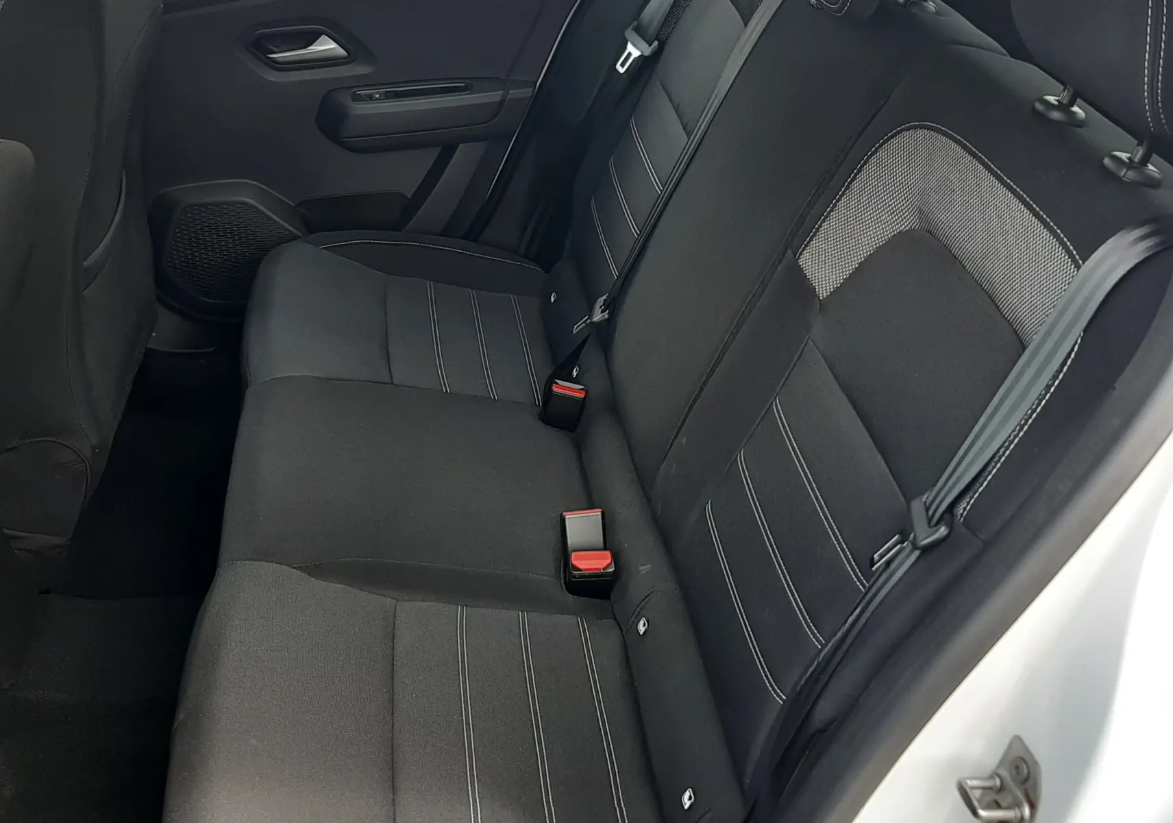 Vue intérieure côté droit des sièges arrière noirs en tissu du Dacia Sandero blanc glacier 2024, version TCE 90CH Expression.