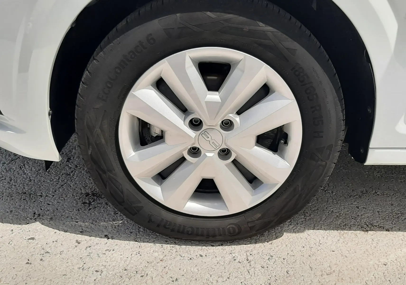 Gros plan sur la roue avant droite blanche glacier d'une Dacia Sandero 2024 avec jante en alliage et pneu Continental.