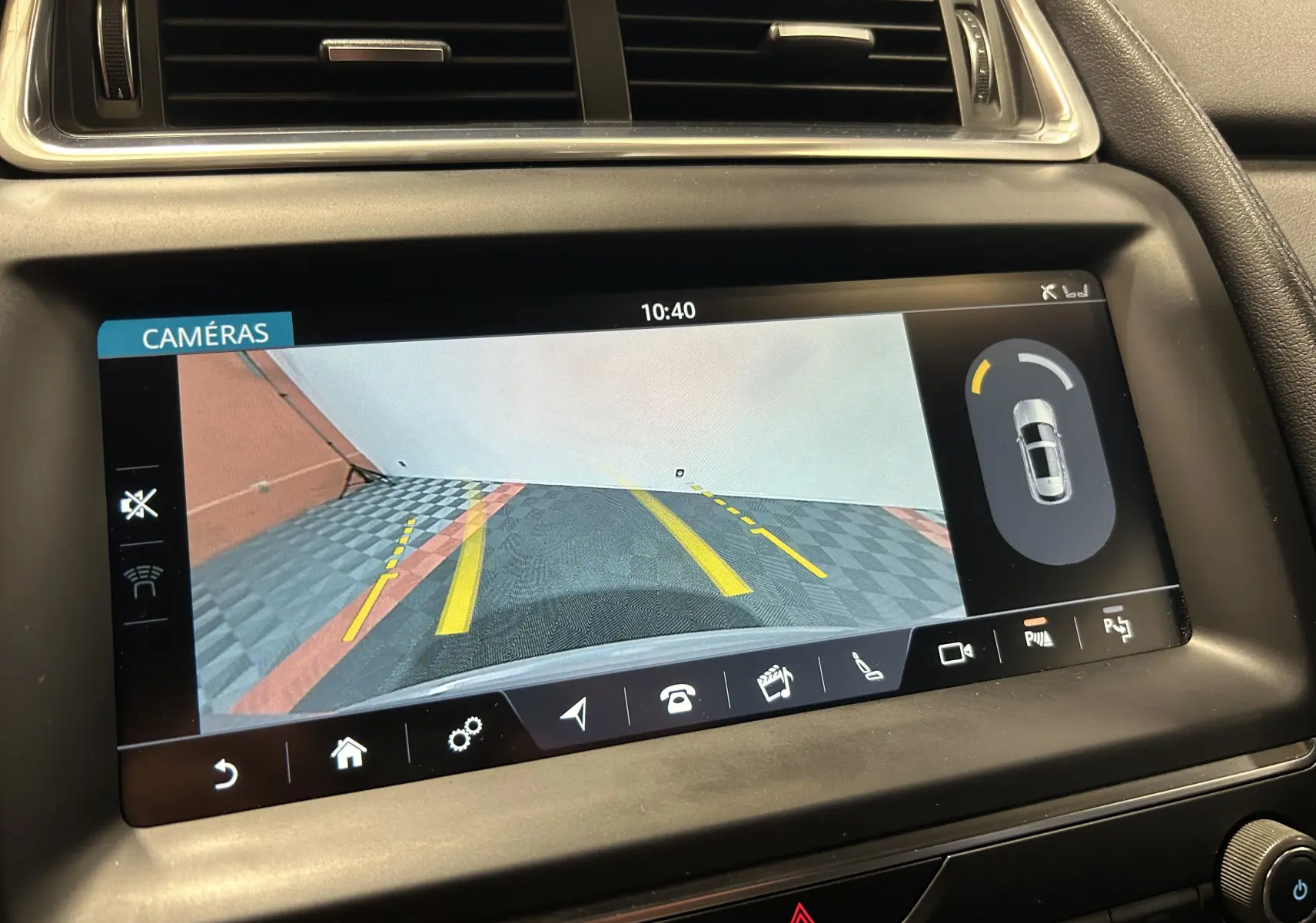 Écran intérieur de Jaguar E-PACE 2018 affichant la caméra de recul avec lignes de guidage jaunes et vue arrière du véhicule.