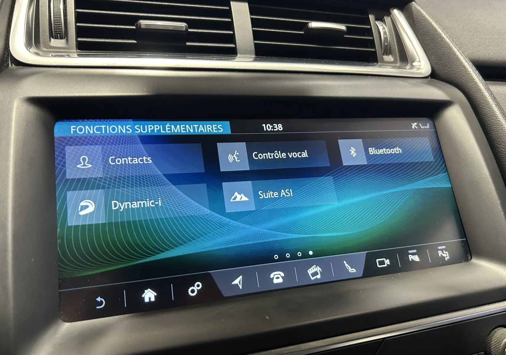 Écran tactile central du tableau de bord de la Jaguar E-PACE beige, affichant les fonctions supplémentaires à 10h38.