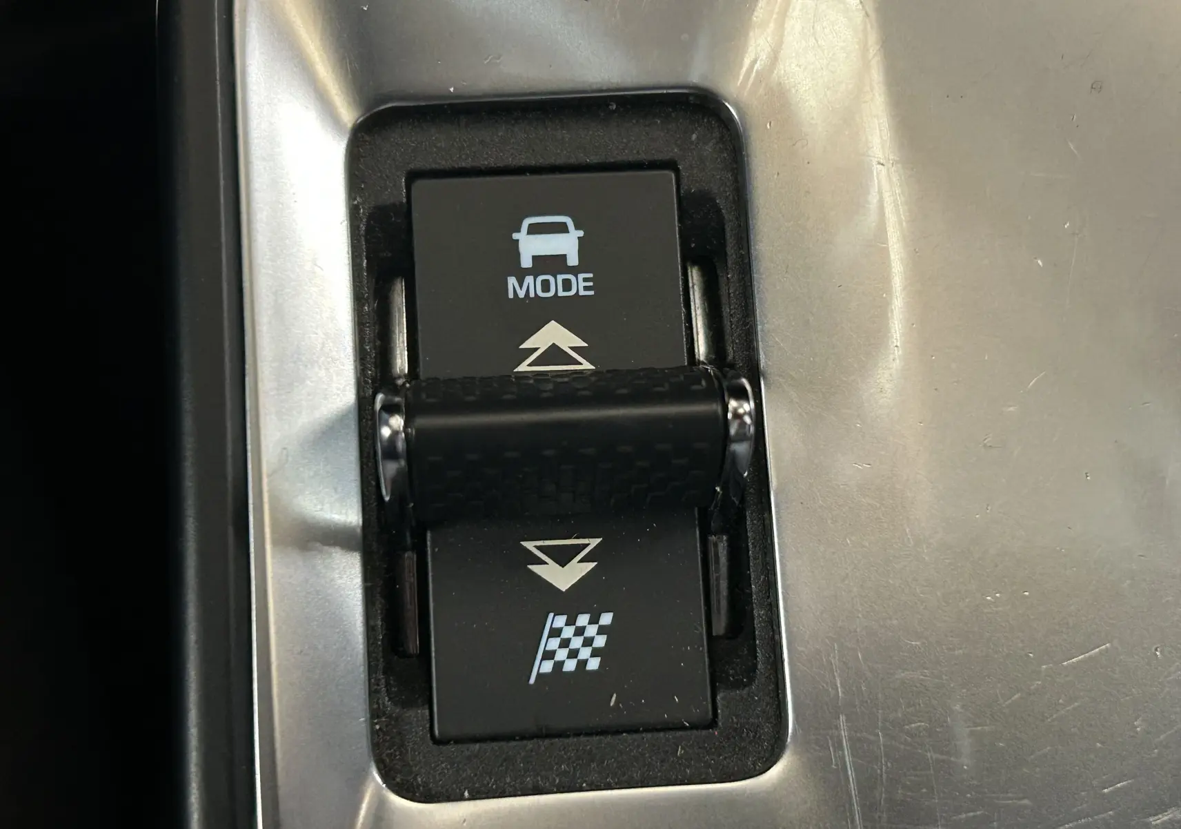 Gros plan sur le bouton de sélection de mode de conduite dans l’habitacle du Jaguar E-PACE beige.
