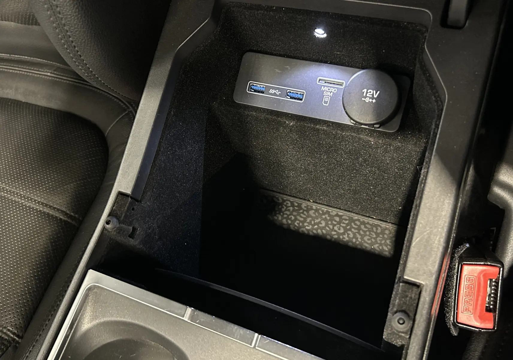 Gros plan sur la console centrale intérieure du Jaguar E-PACE, montrant prises USB, port micro SIM et prise 12V.