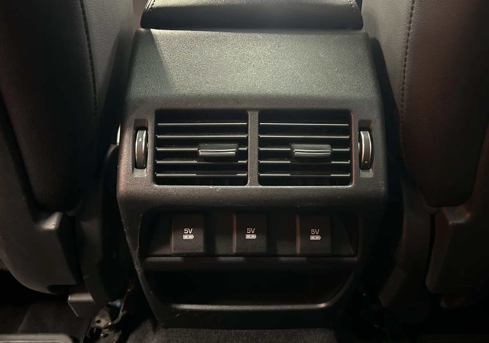 Détail de la console arrière avec bouches d’aération et ports USB 5V du Jaguar E-PACE beige 2018.