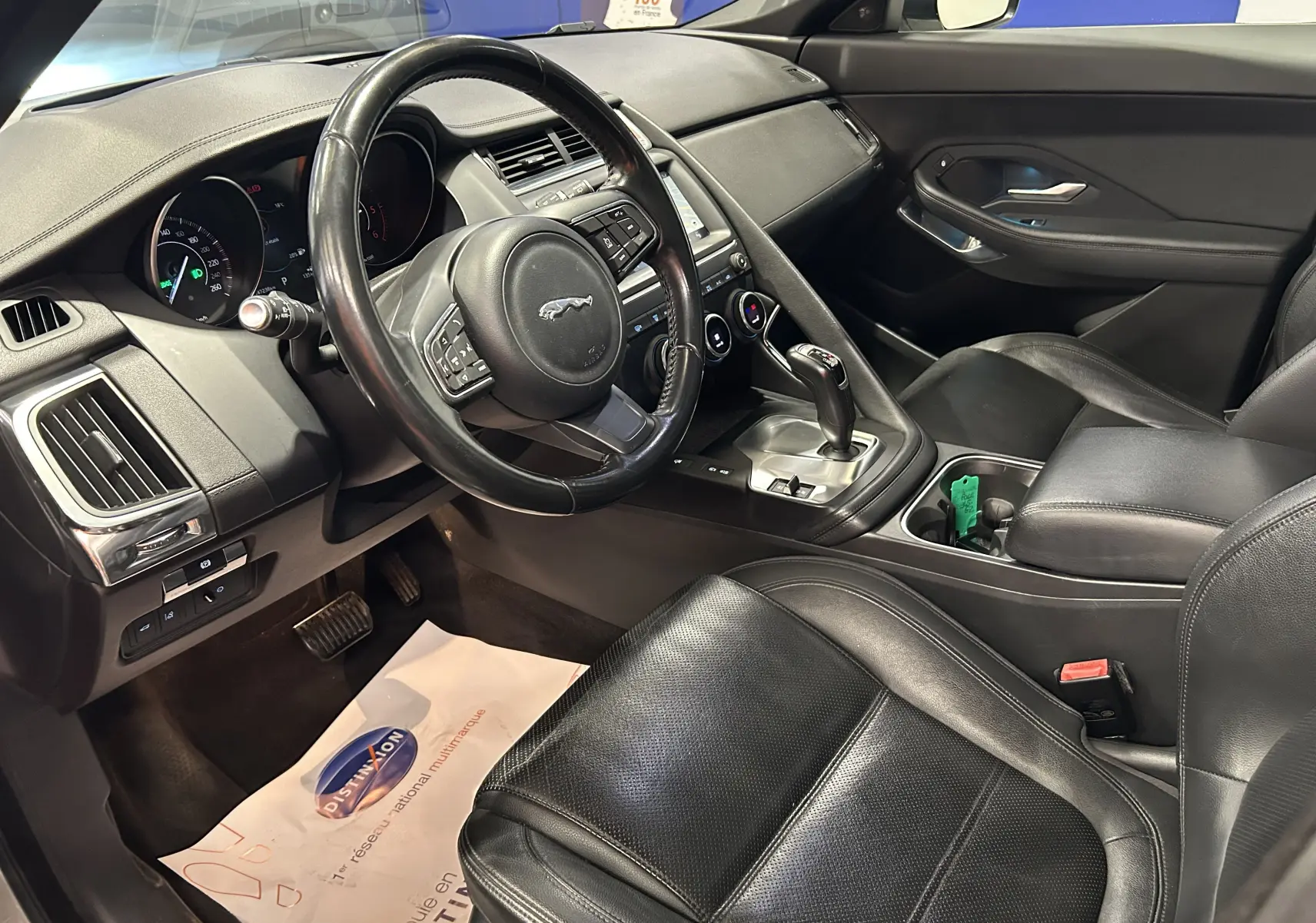 Vue intérieure côté conducteur du Jaguar E-PACE 2018 avec sièges cuir noirs et console centrale équipée d'une boîte automatique.