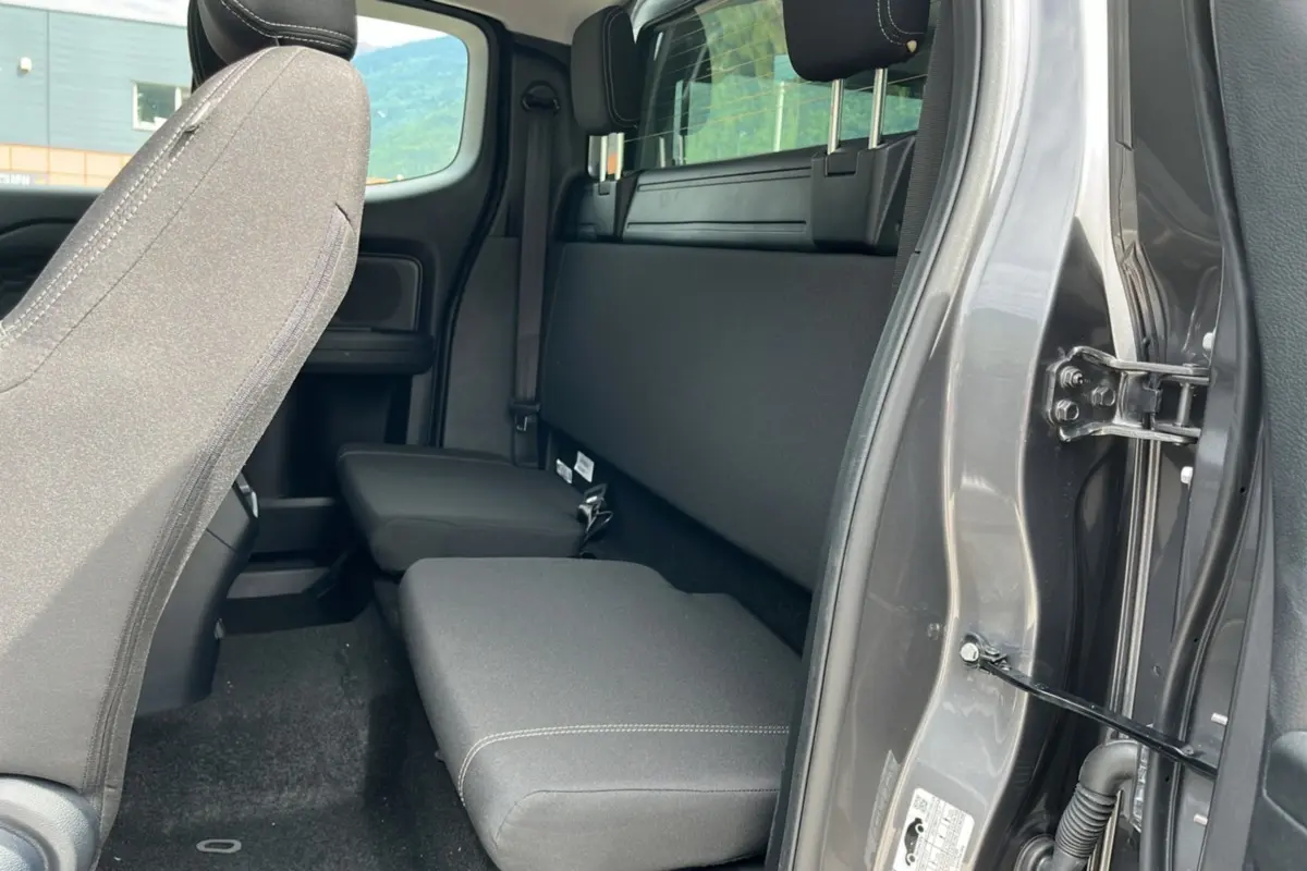 Vue intérieure côté droit du Ford Ranger 2025 gris carbone, montrant la banquette arrière et l'ouverture de porte SuperCab.