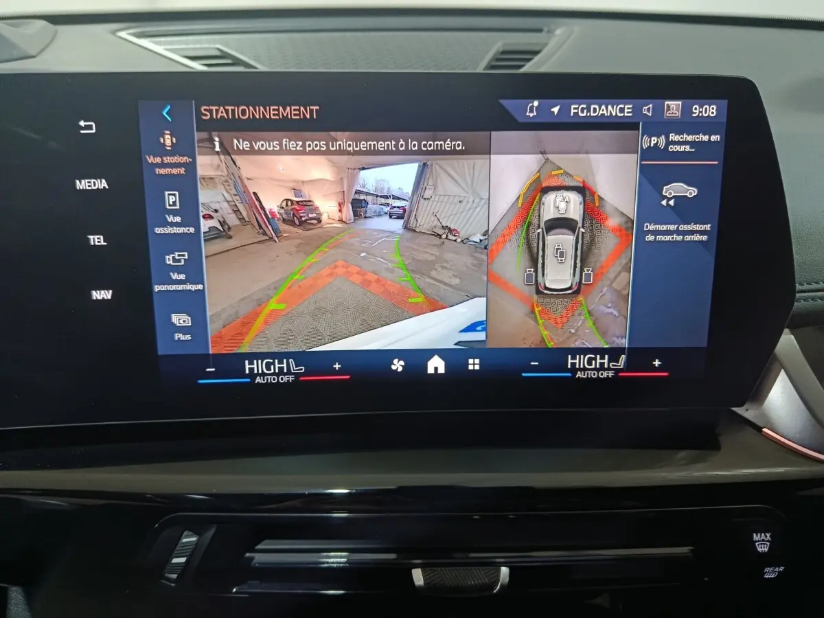 Écran tactile intérieur montrant l’aide au stationnement avec vue arrière et vue 360° du BMW X1 blanc xDrive25e.