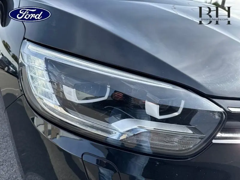 Gros plan sur le phare avant droit noir étoilé du Renault Grand Scenic 2017, mettant en valeur ses lignes modernes.