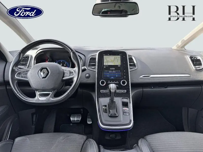 Vue intérieure avant du Renault Grand Scenic noir étoilé 2017, tableau de bord avec écran tactile central et volant cuir.