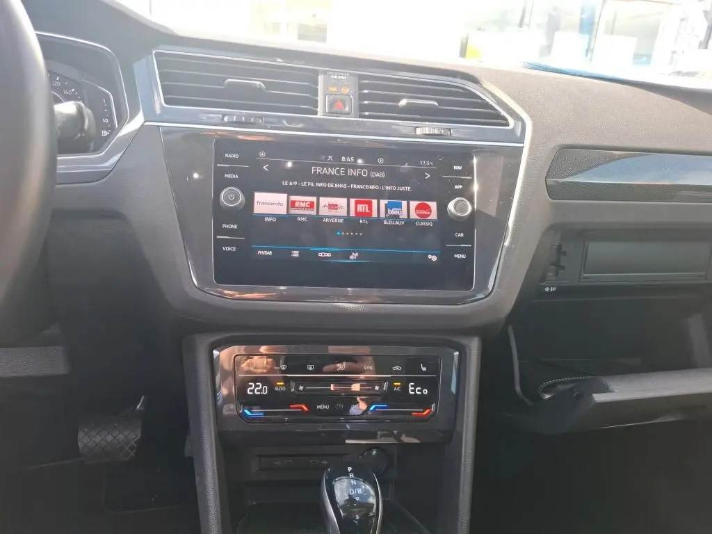 Vue intérieure du tableau de bord du Volkswagen Tiguan 1.4 e-Hybrid 2022 avec écran tactile et commandes climatisation digitales.