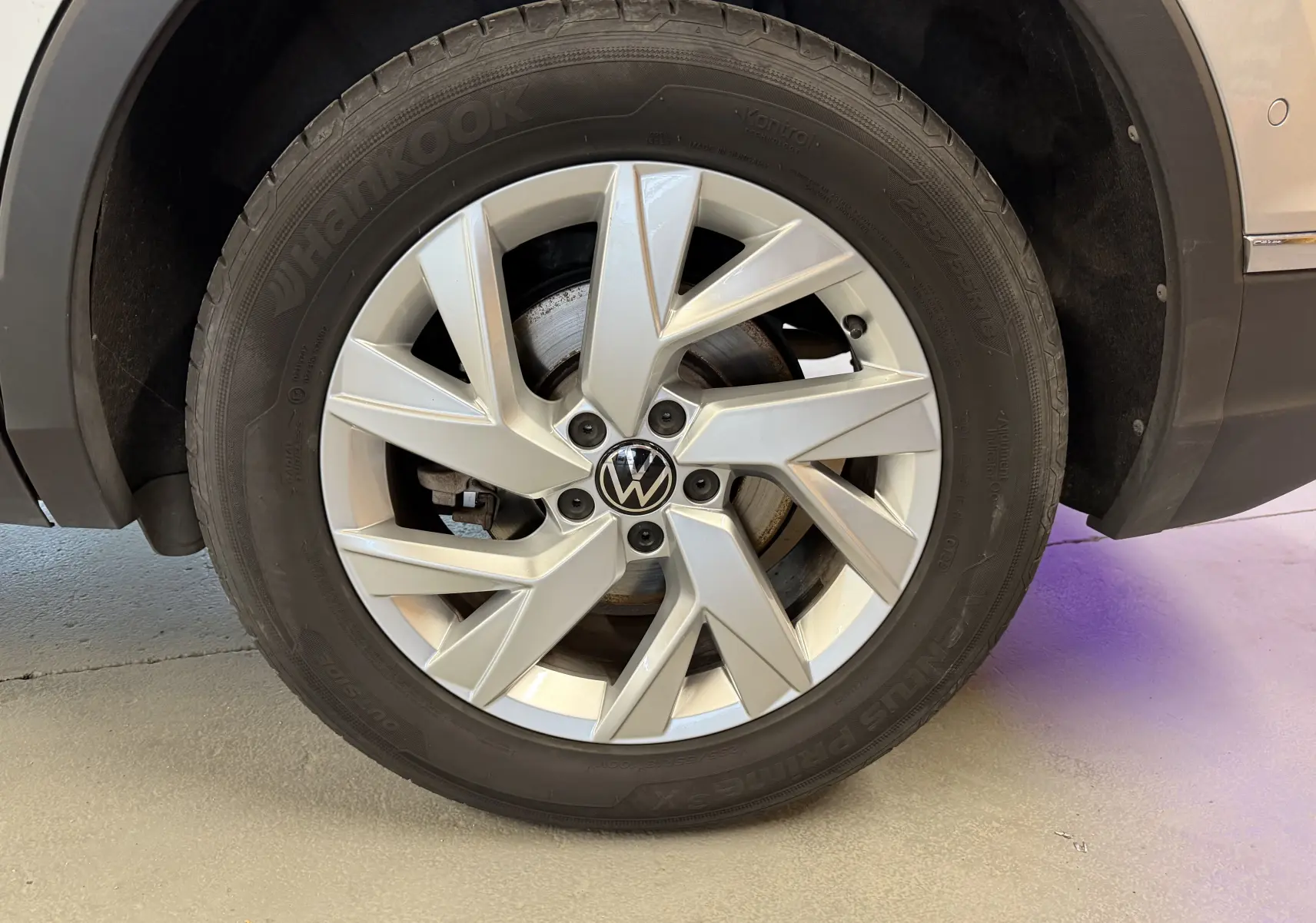 Gros plan sur la roue avant droite d’un Volkswagen Tiguan gris clair, mettant en valeur la jante alliage et le pneu Hankook.