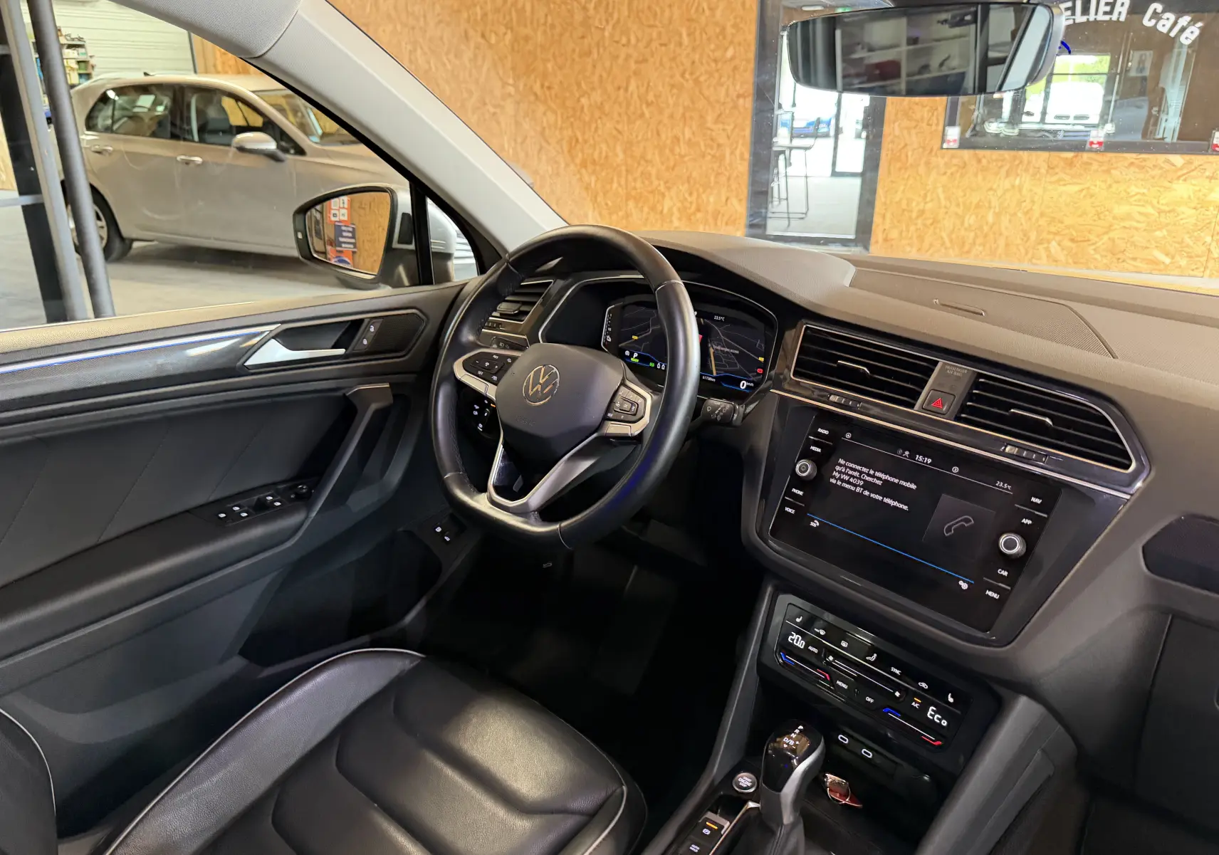 Vue intérieure côté conducteur du Volkswagen Tiguan 1.4 e-Hybrid 2022, tableau de bord noir avec écran tactile et volant multifonction.