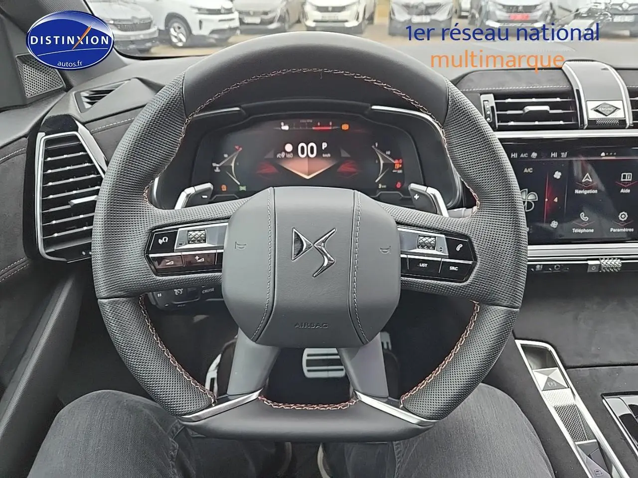 Vue rapprochée du volant cuir DS noir avec commandes intégrées et tableau de bord numérique du DS7 2025.