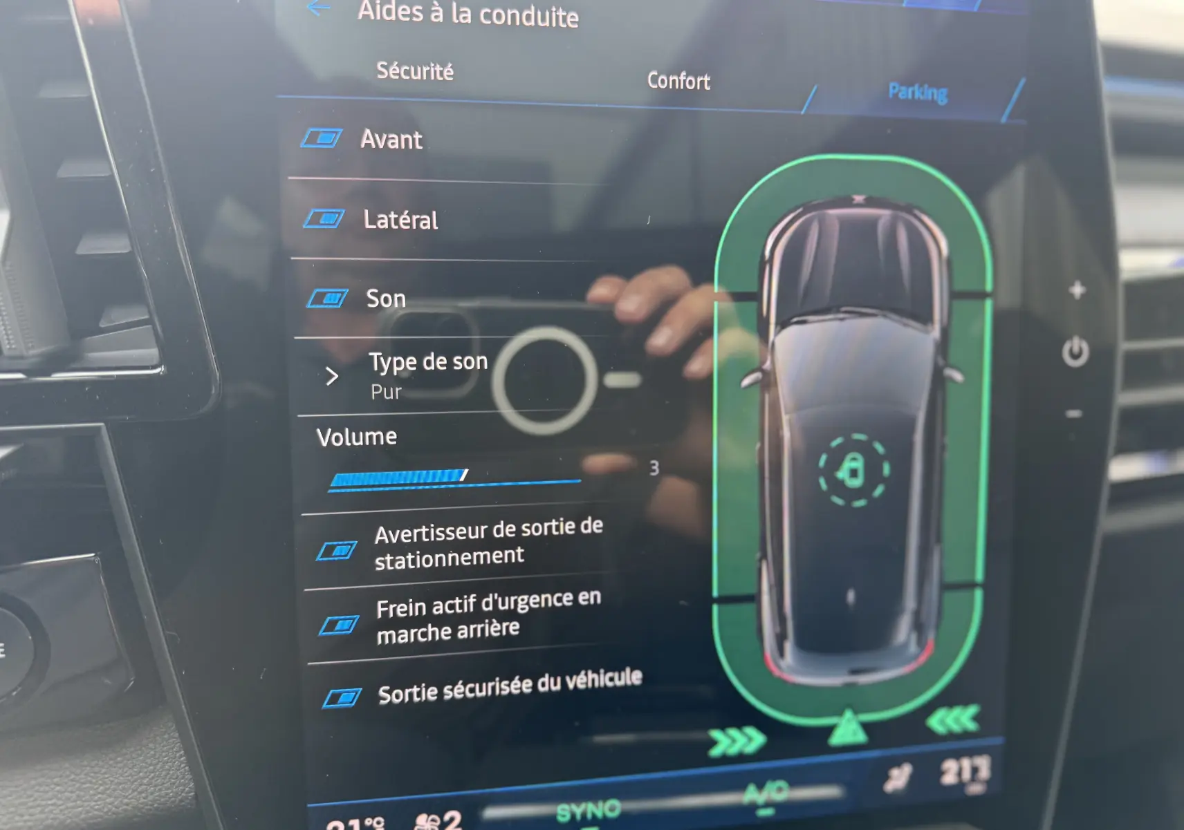 Écran tactile du tableau de bord du Renault Austral 2025 montrant les aides à la conduite et la vue top-down du véhicule bleu iron toit noir.