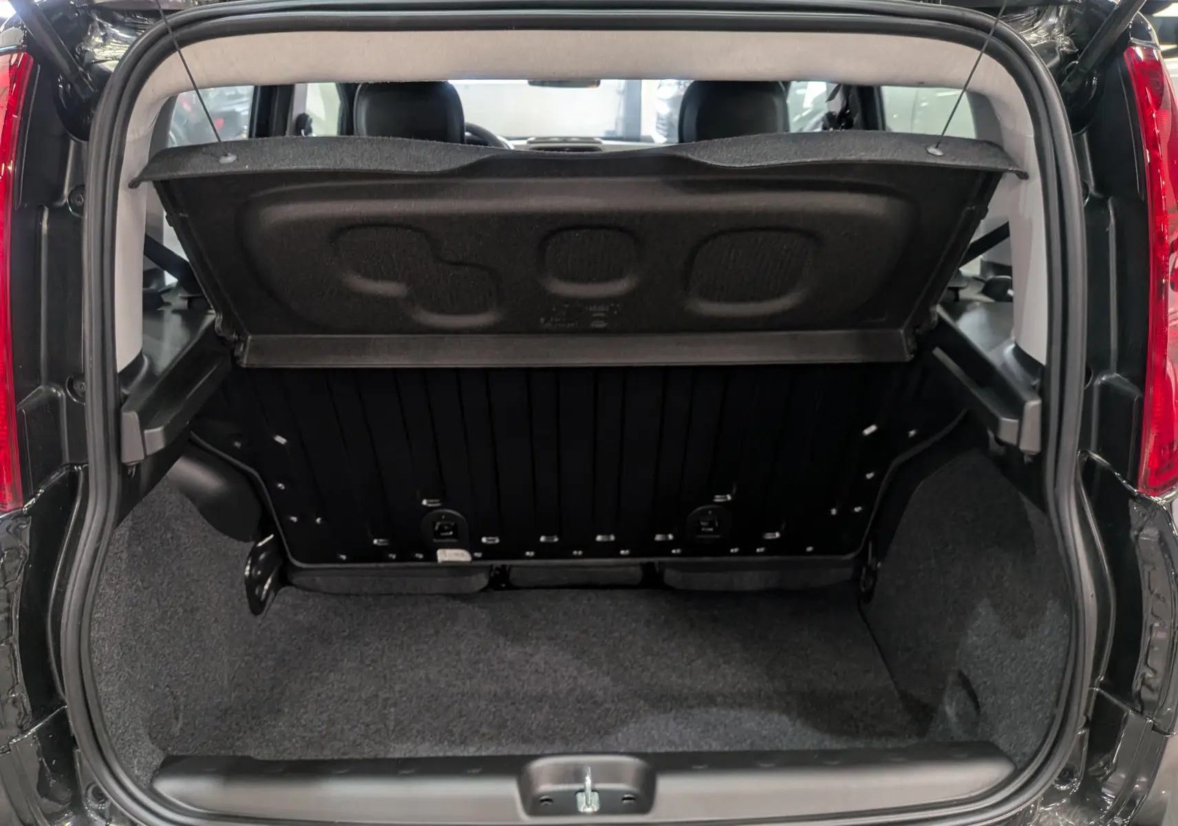 Coffre ouvert de la Fiat Panda 1.0 70 CH Hybrid City 2025 en Noir Cinéma, montrant l'espace de rangement arrière.