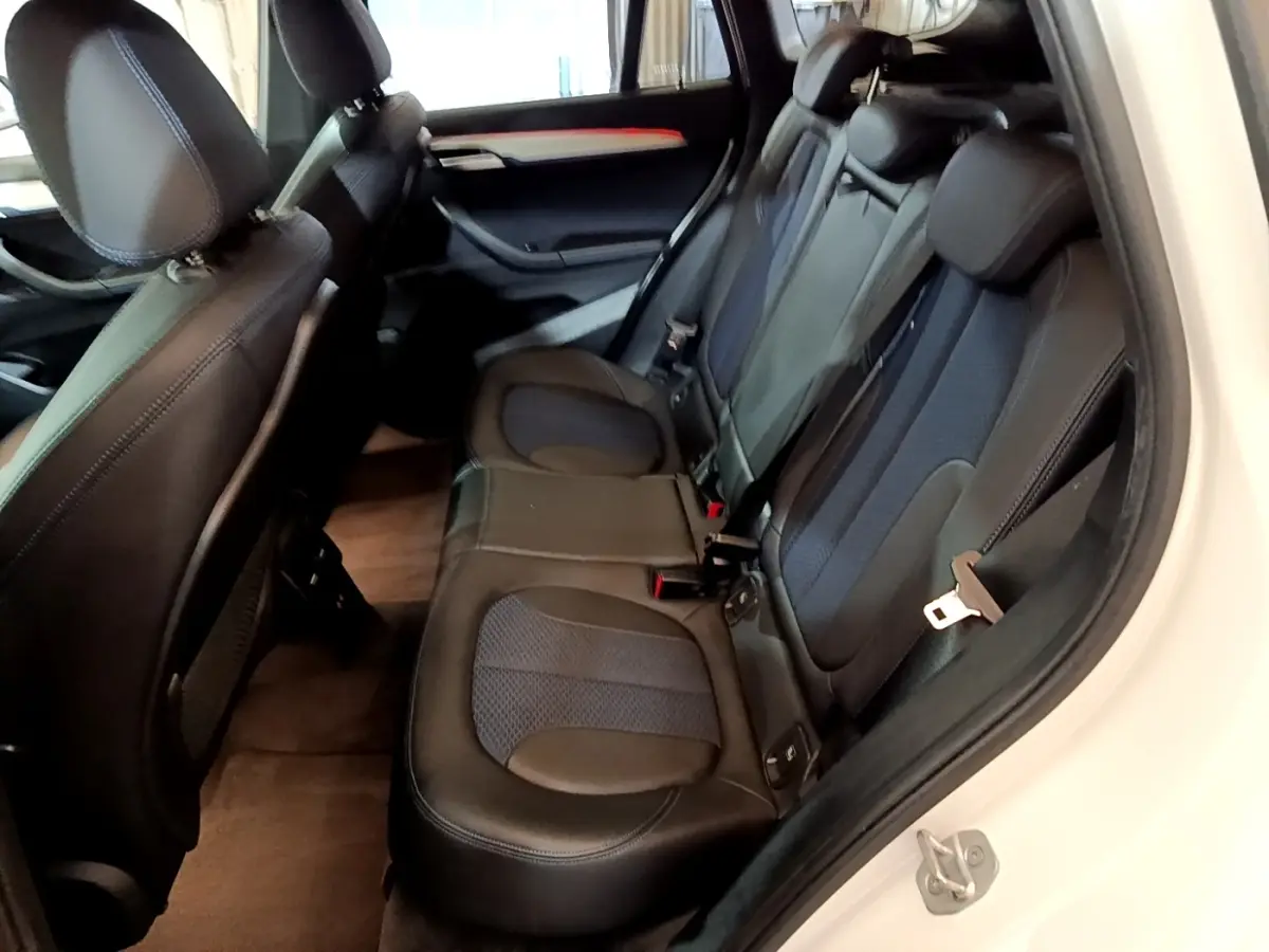 Vue intérieure côté droit des sièges arrière en cuir noir du BMW X1 sDrive18i M Sport blanc de 2022.