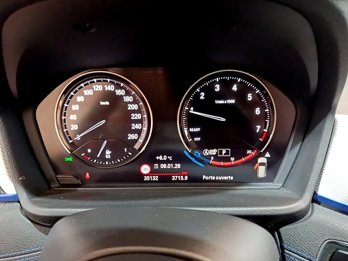 Vue rapprochée du tableau de bord numérique de la BMW X1 sDrive18i M Sport 2022, affichage clair des compteurs et alertes.