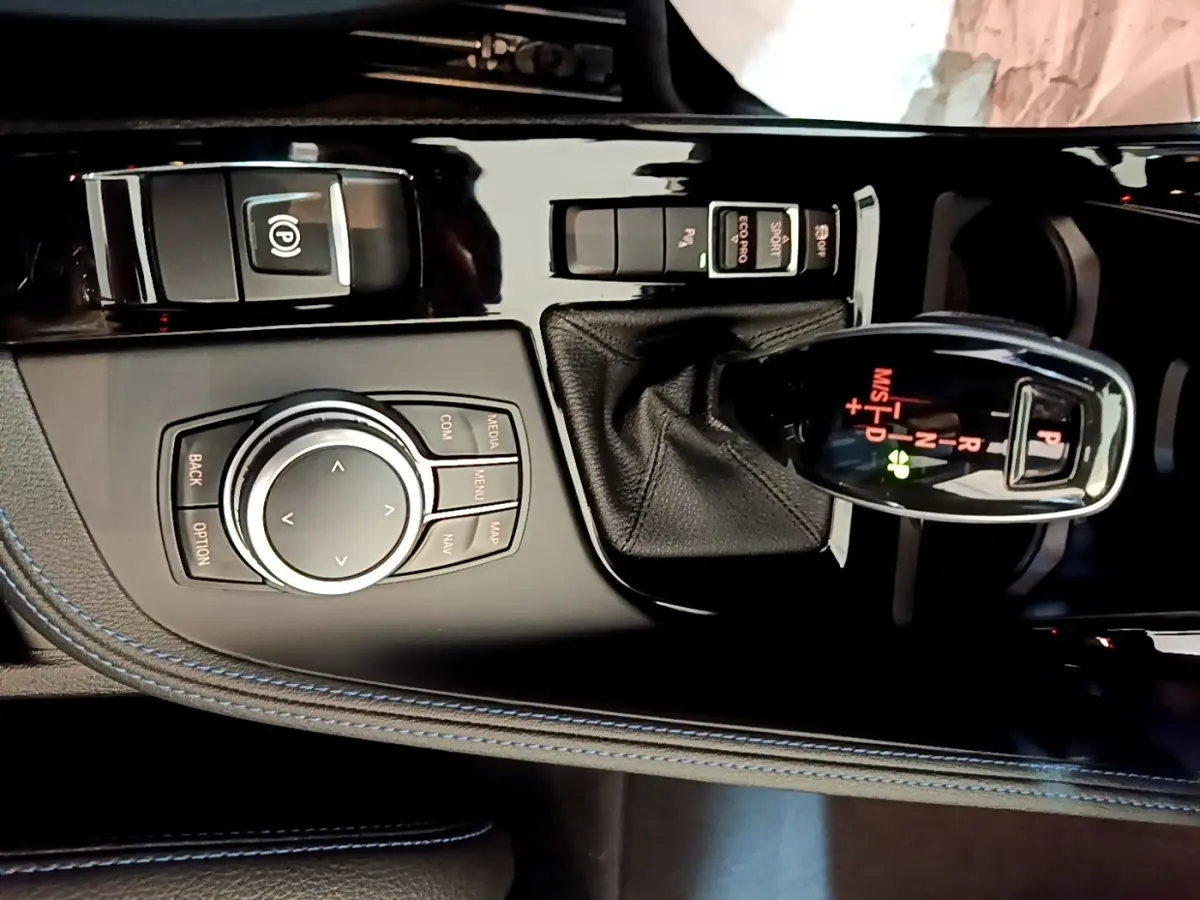 Gros plan sur la console centrale noire du BMW X1 sDrive18i M Sport 2022, avec levier de vitesses et molette de contrôle.