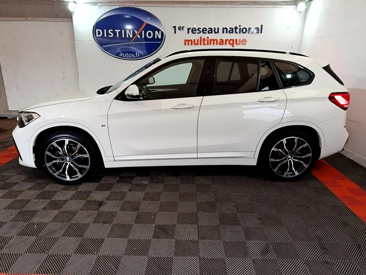 BMW X1 sDrive18i M Sport blanc vue de profil côté gauche avec jantes alliage et vitres teintées.