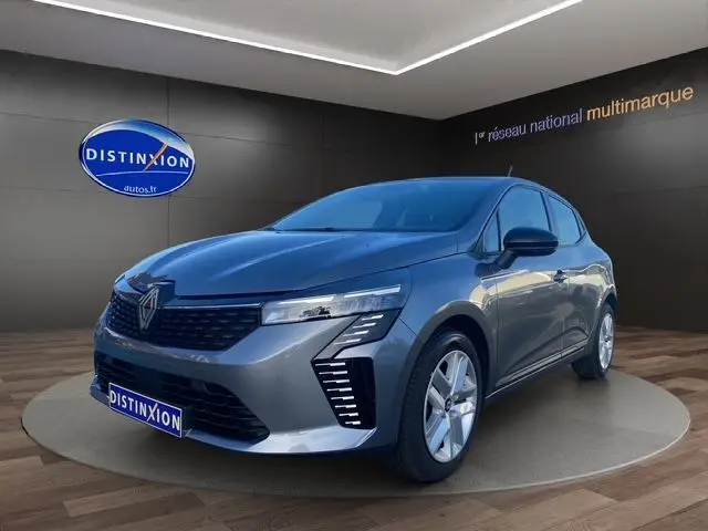 Renault Clio V gris schiste vue 3/4 avant droit, avec feux LED et jantes alliage 16 pouces visibles.