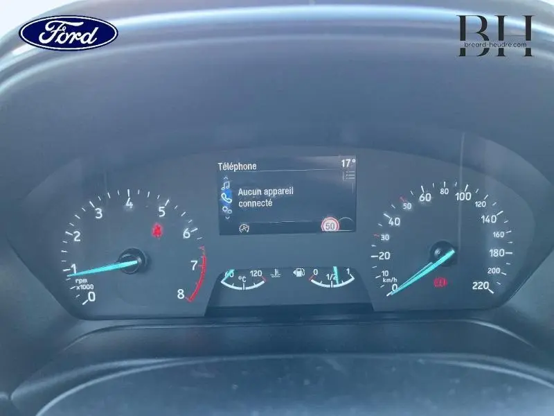 Vue rapprochée du tableau de bord numérique du Ford Puma blanc, affichant compte-tours, vitesse et écran central connecté.