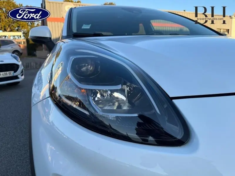 Gros plan sur le phare avant droit du Ford Puma blanc 2022, mettant en valeur son design moderne et épuré.