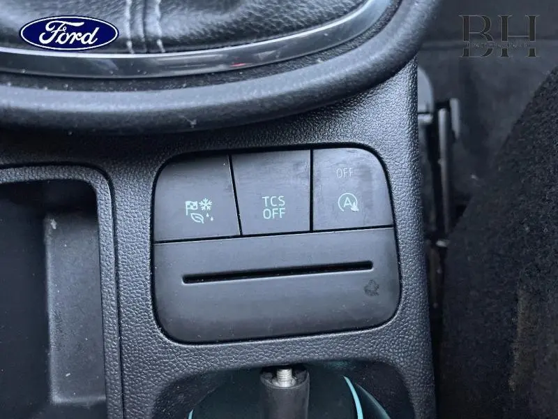 Gros plan sur les boutons de commande du système de sécurité et arrêt auto du moteur dans une Ford Puma blanche.