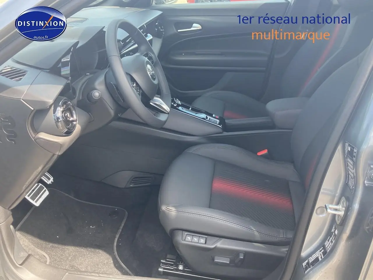 Vue intérieure côté conducteur de l'Alfa Romeo Junior 1.2 hybride grise, avec sièges cuir noir et console centrale moderne.