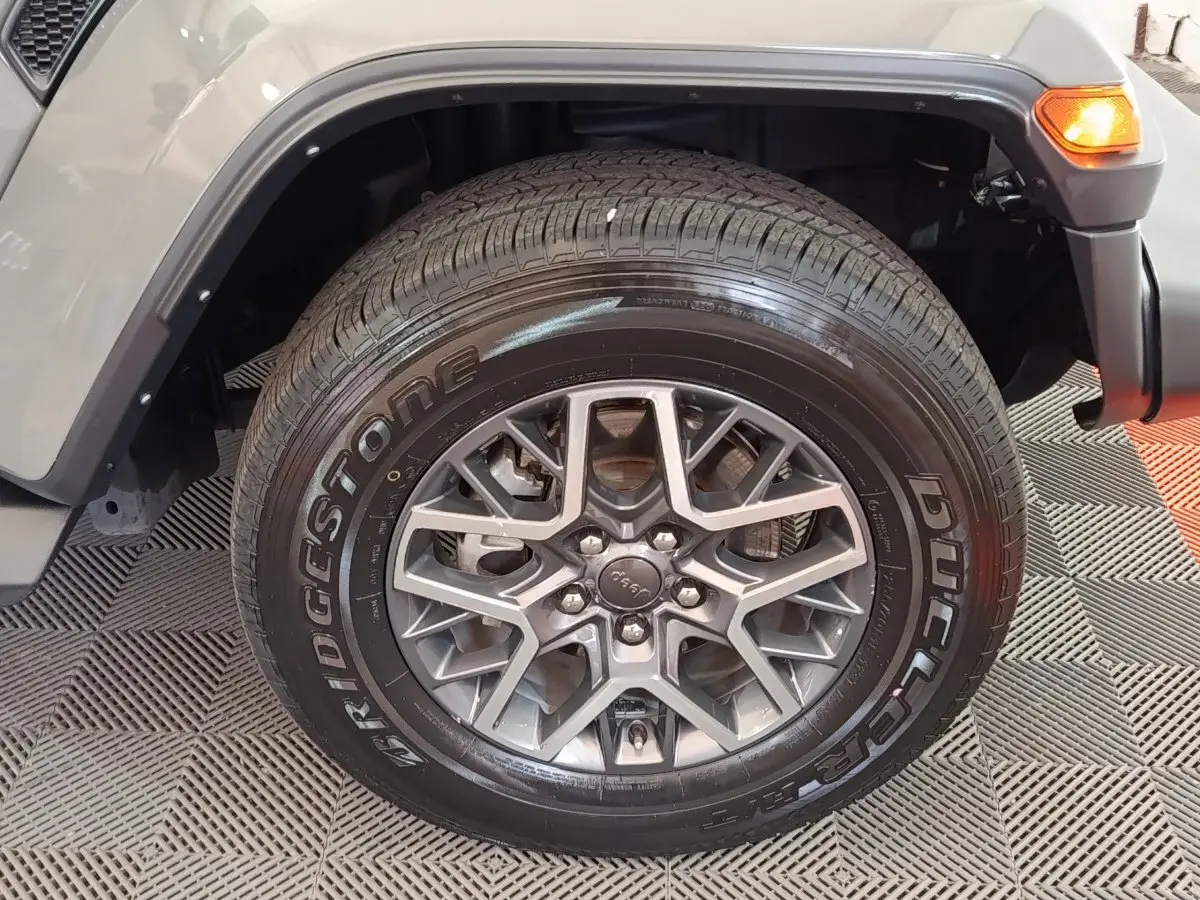 Gros plan sur la roue avant droite gris foncé du Jeep Wrangler 2022 avec jante aluminium et pneu Bridgestone.