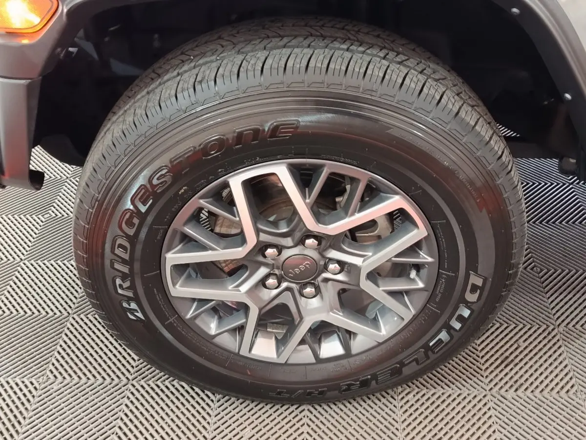 Gros plan sur la roue avant droite gris foncé du Jeep Wrangler 2022 avec jante aluminium et pneu Bridgestone.