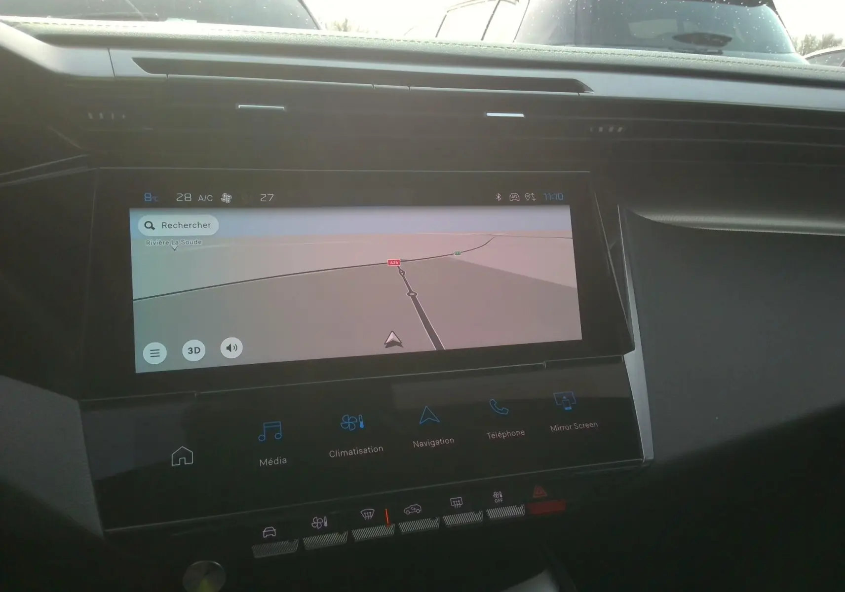 Écran tactile central de la Peugeot 308 1.6 PHEV 225 GT 2024 montrant la navigation, intérieur noir visible.