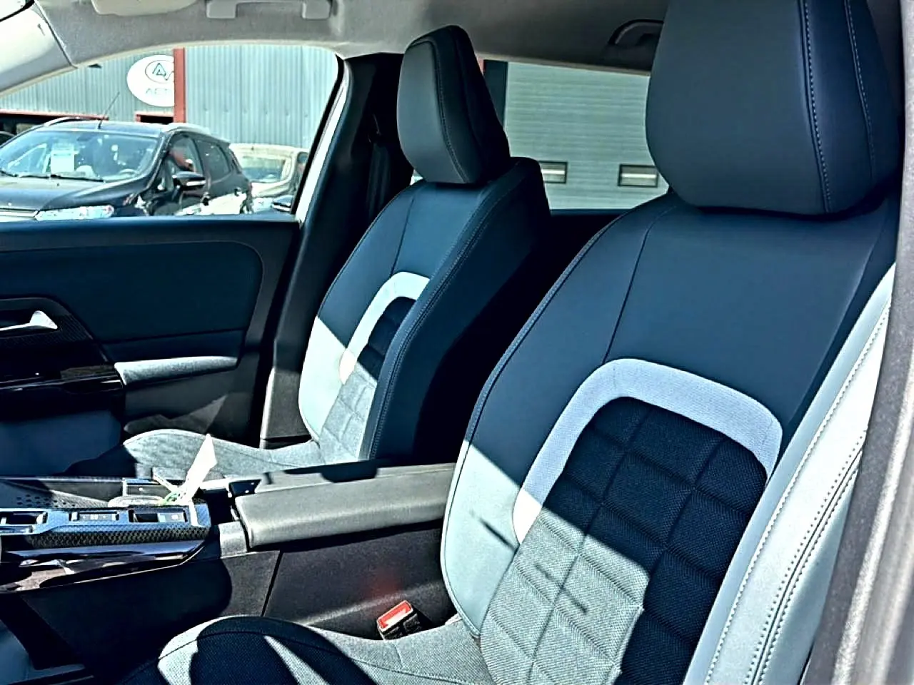 Vue intérieure côté conducteur du Citroën C5 Aircross 2026, sièges bi-matière noir et gris avec accoudoir central.