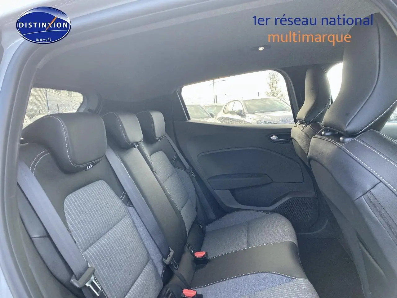 Vue intérieure arrière de la Renault Clio V gris rafale, montrant la banquette 3 places avec ceintures et appuie-têtes.