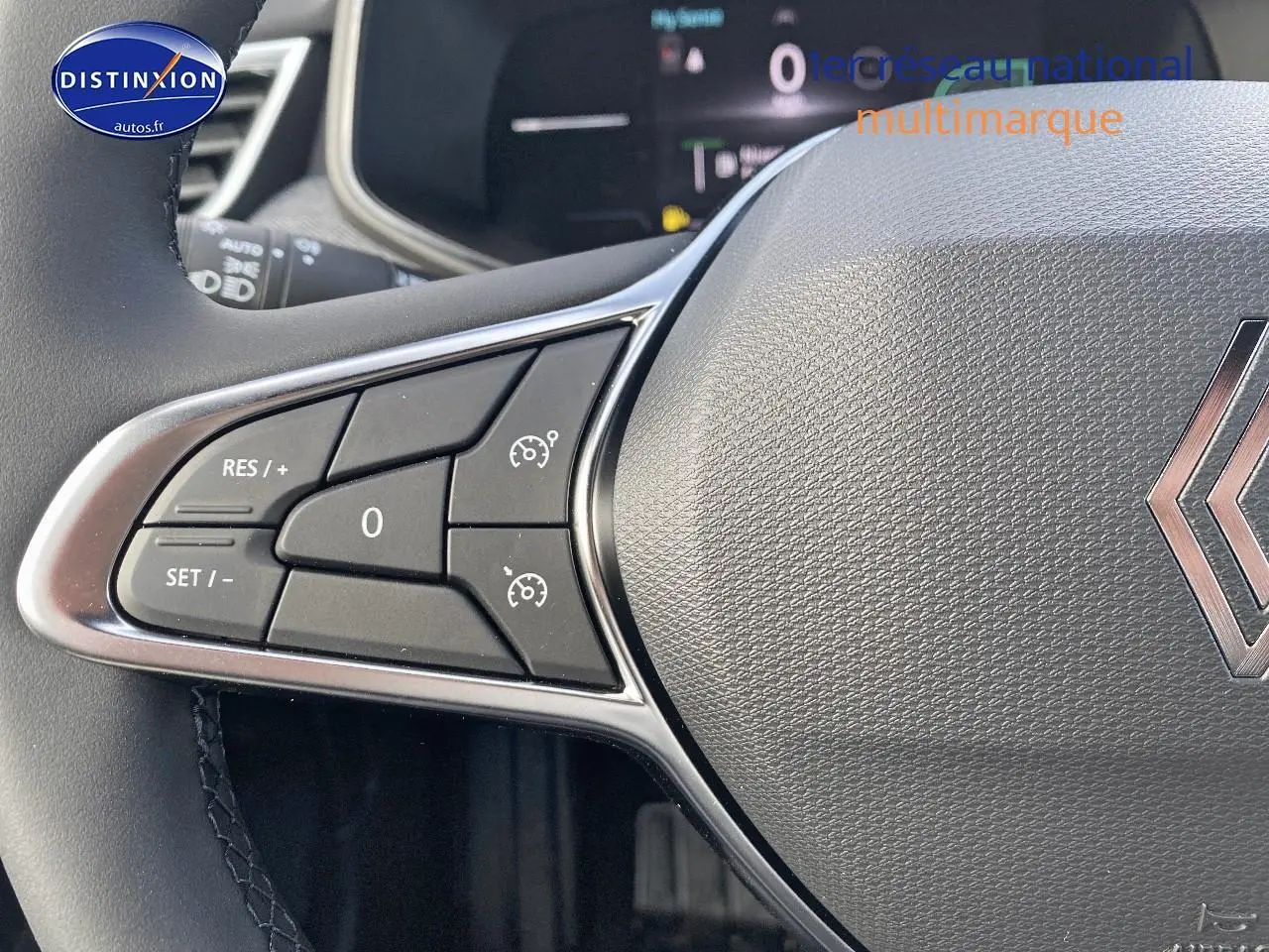 Gros plan sur le volant multifonction gris avec commandes de régulateur de vitesse de la Renault Clio V.