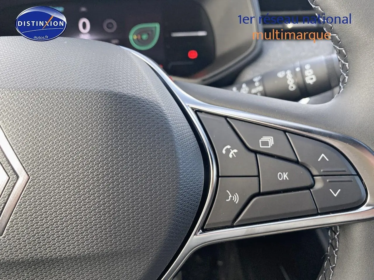 Gros plan sur les commandes multifonctions du volant côté droit de la Renault Clio V gris rafale.