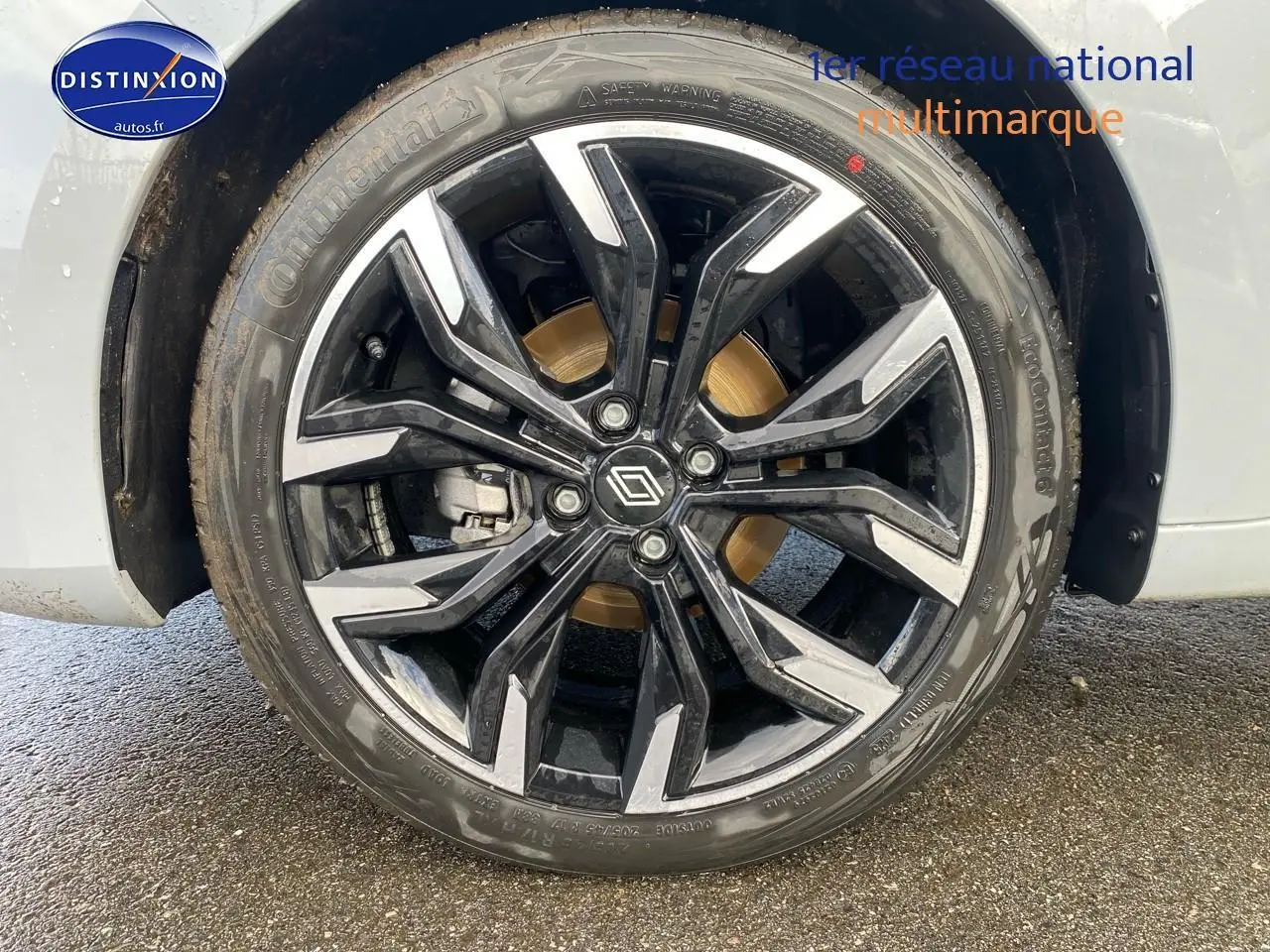 Gros plan sur la jante alu noire et argentée de la Renault Clio V gris rafale, avec pneu Continental visible.