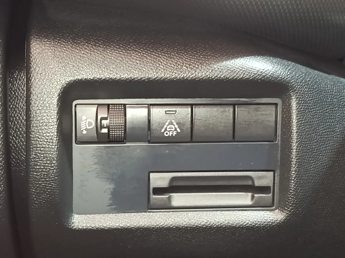 Détail intérieur du tableau de bord noir du Citroën C5 Aircross 2024 avec commandes d'éclairage et d'aide à la conduite.