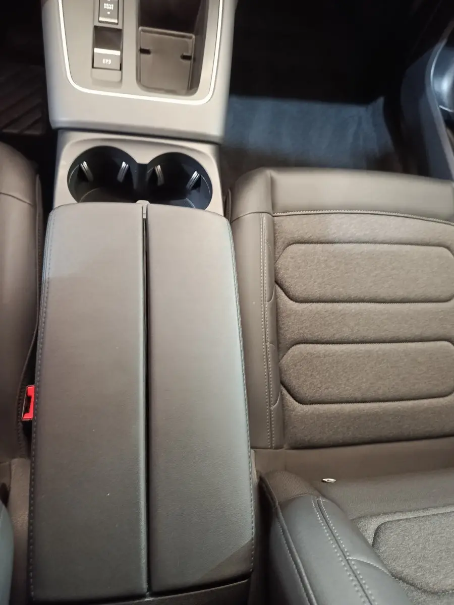 Vue rapprochée de l'accoudoir central noir et du siège passager en tissu et cuir du Citroën C5 Aircross 2024.