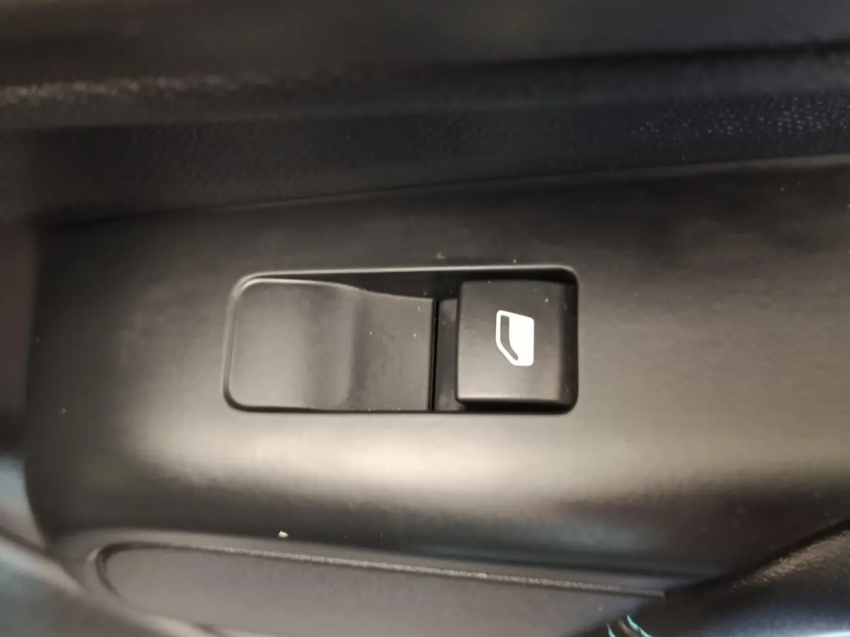 Gros plan sur le bouton de commande de vitre électrique noir dans l'habitacle du Citroën C5 Aircross 2024.