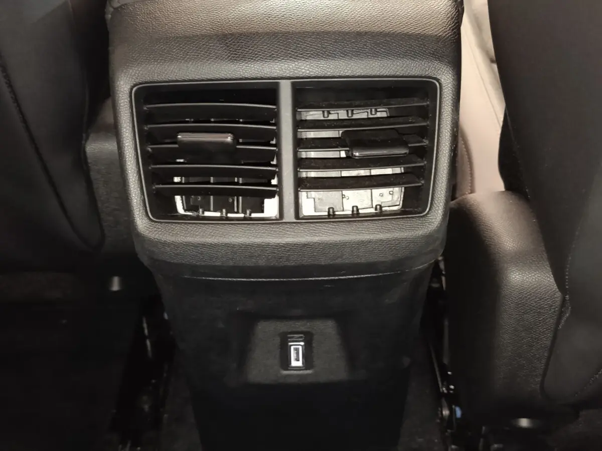 Vue rapprochée des aérateurs arrière noirs et prise USB du Citroën C5 Aircross 2024 côté arrière des sièges avant.