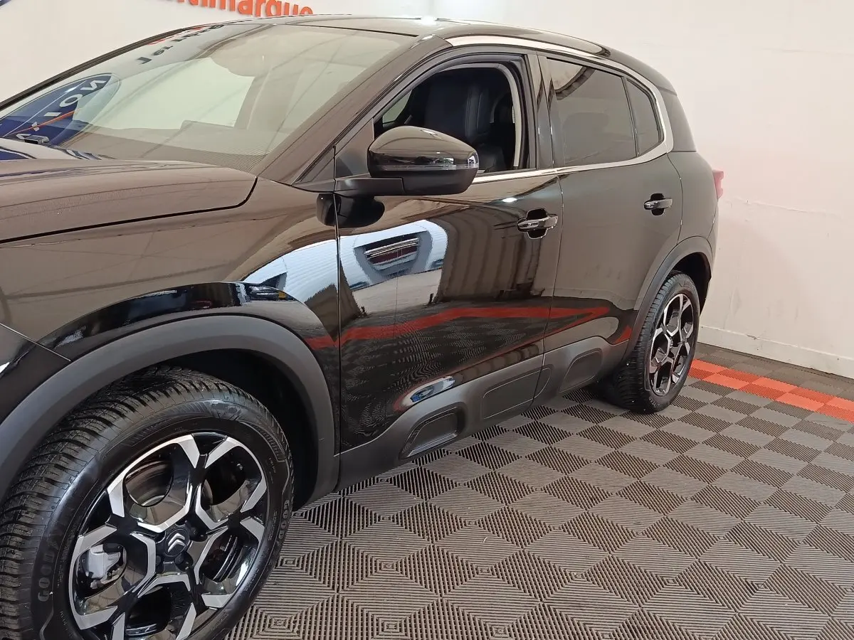 Vue côté gauche 3/4 arrière du Citroën C5 Aircross noir avec jantes alliage et protections de bas de caisse.