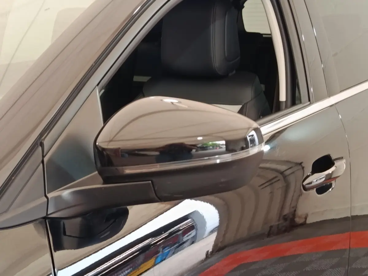Gros plan sur le rétroviseur côté gauche d’un Citroën C5 Aircross noir 2024 avec poignée de porte visible.